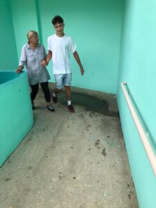 Joven-apoyando-a-señora-de-camino-a-buscar-su-almuerzo-comerio